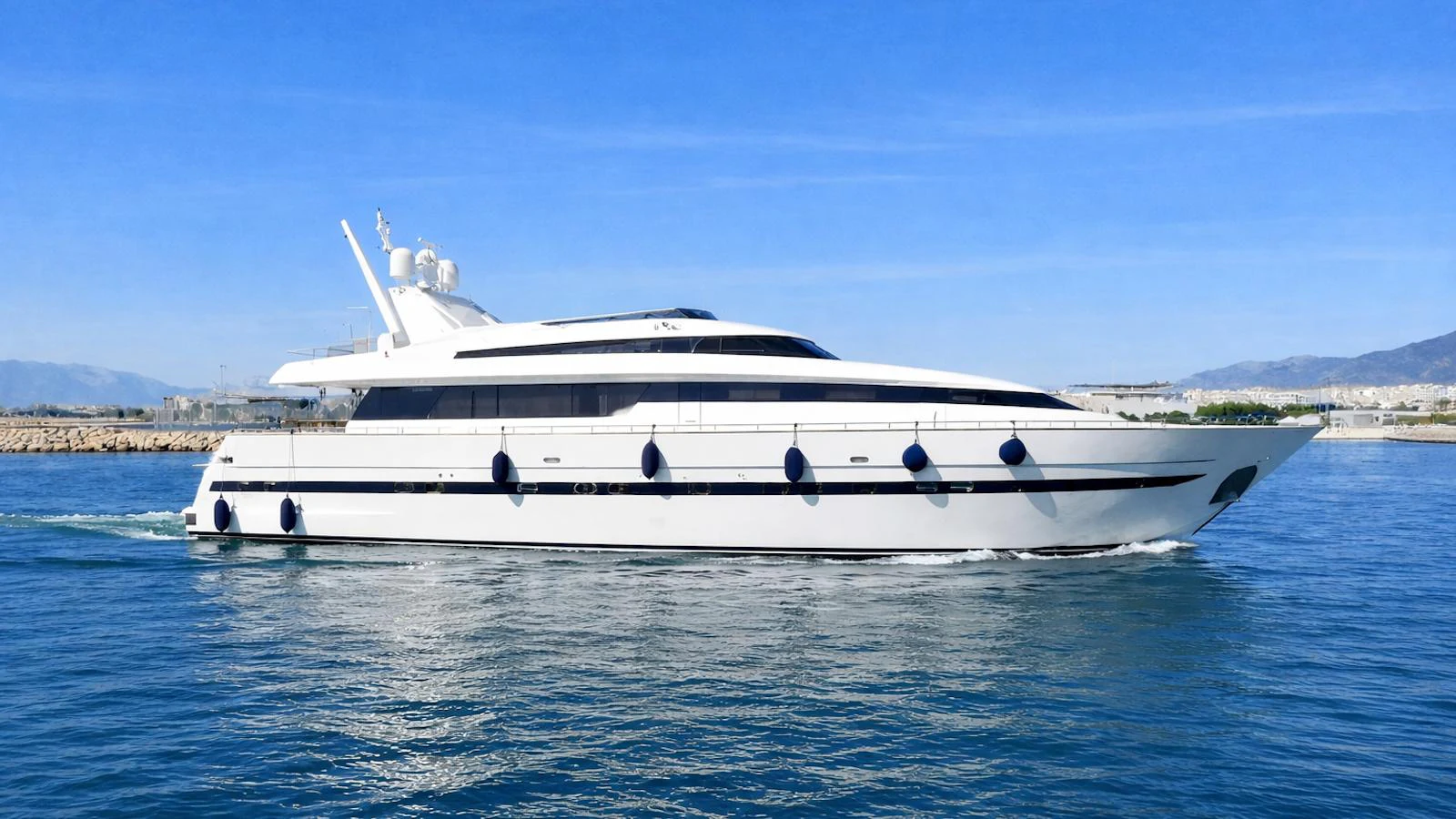 A sleek and modern yacht glides gracefully on calm waters under a clear blue sky. aboard BLUE RIBBON Yacht for Sale