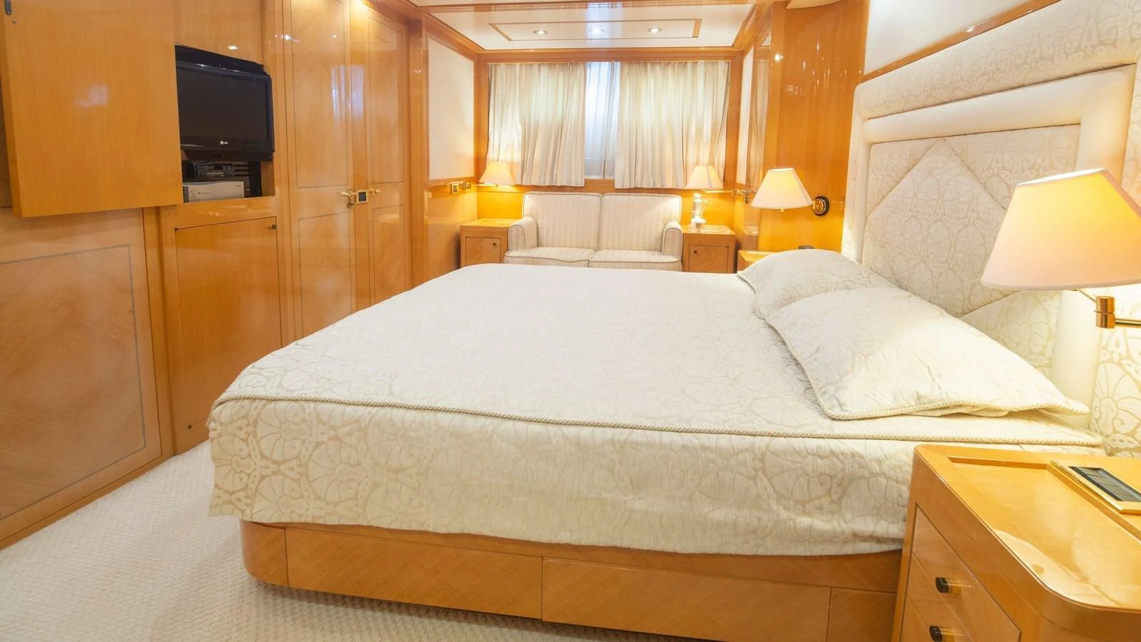 The master stateroom features a spacious bed, warm wood finishes, and soft lighting for a luxurious retreat. aboard BLUE RIBBON Yacht for Sale