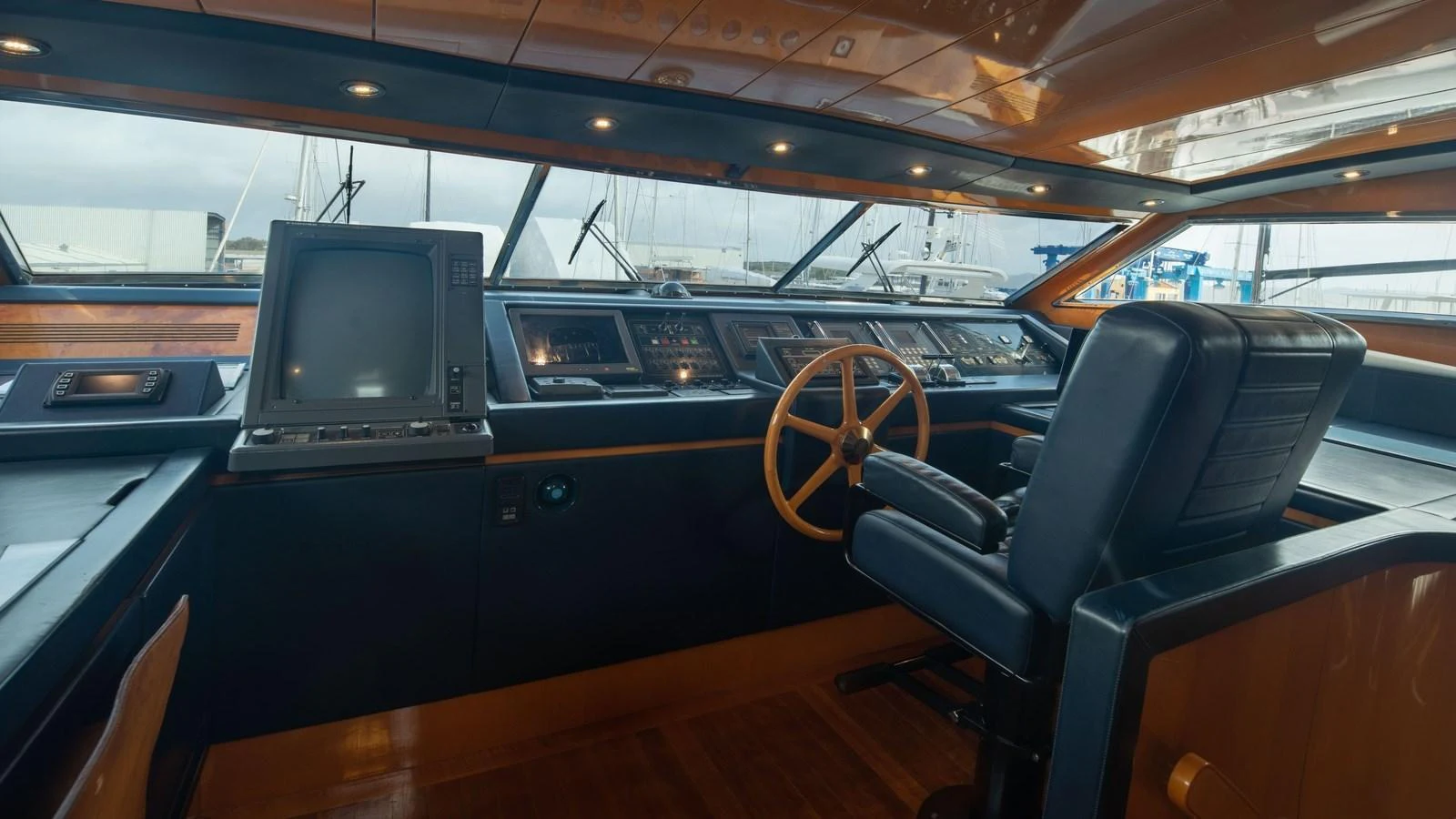 The helm station features a sophisticated control panel and a comfortable captain's chair. aboard BLUE RIBBON Yacht for Sale