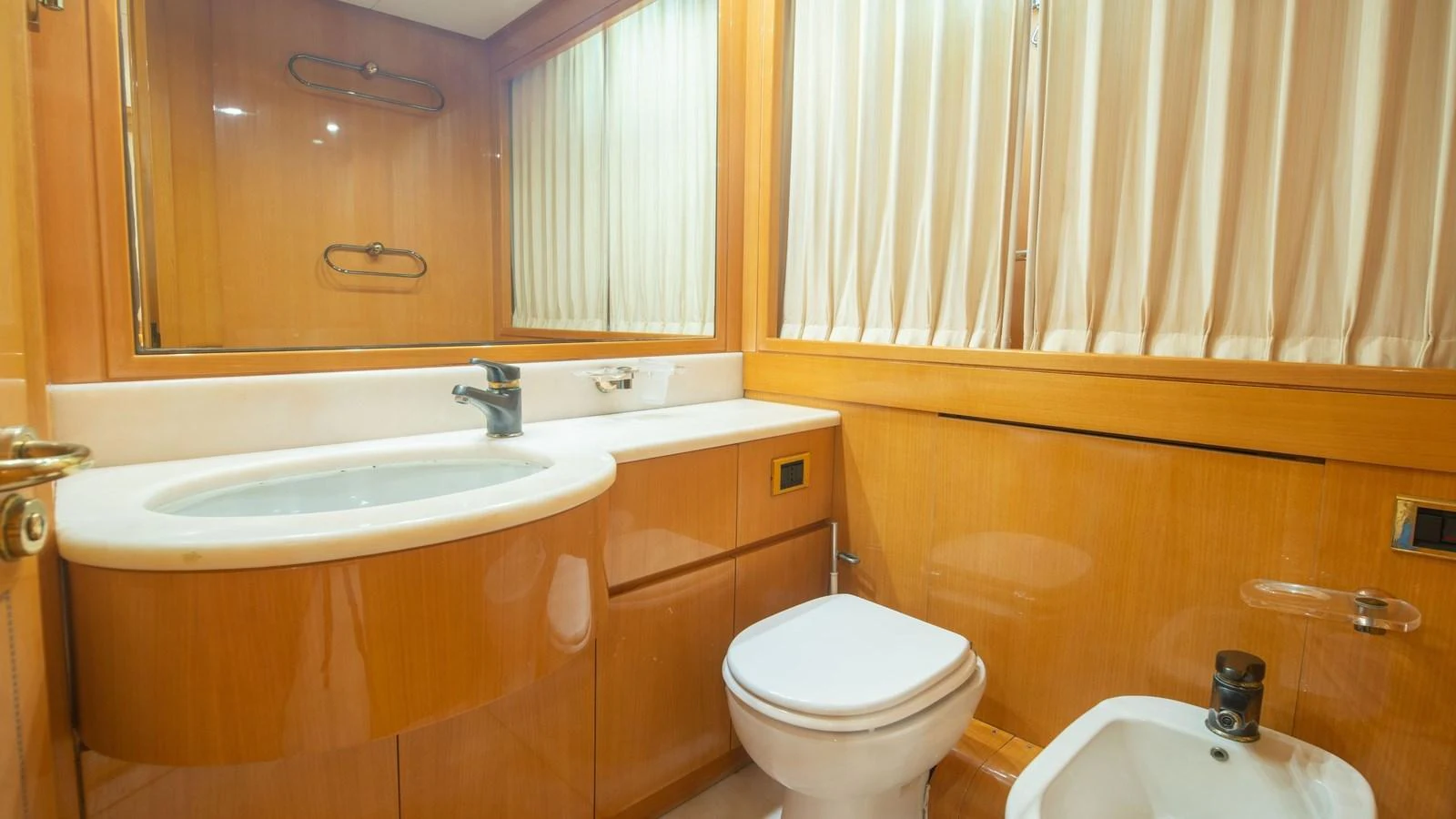 The yacht's bathroom features a sleek design with wooden cabinetry and modern fixtures. aboard BLUE RIBBON Yacht for Sale