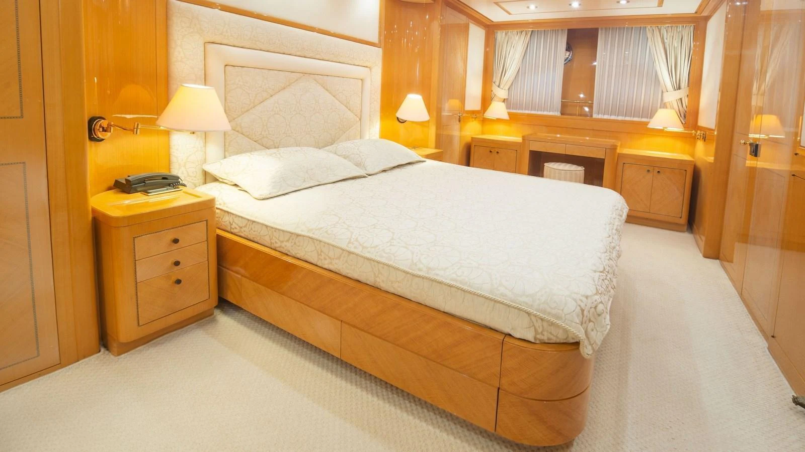 The master stateroom features a luxurious bed with elegant lighting and ample storage. aboard BLUE RIBBON Yacht for Sale