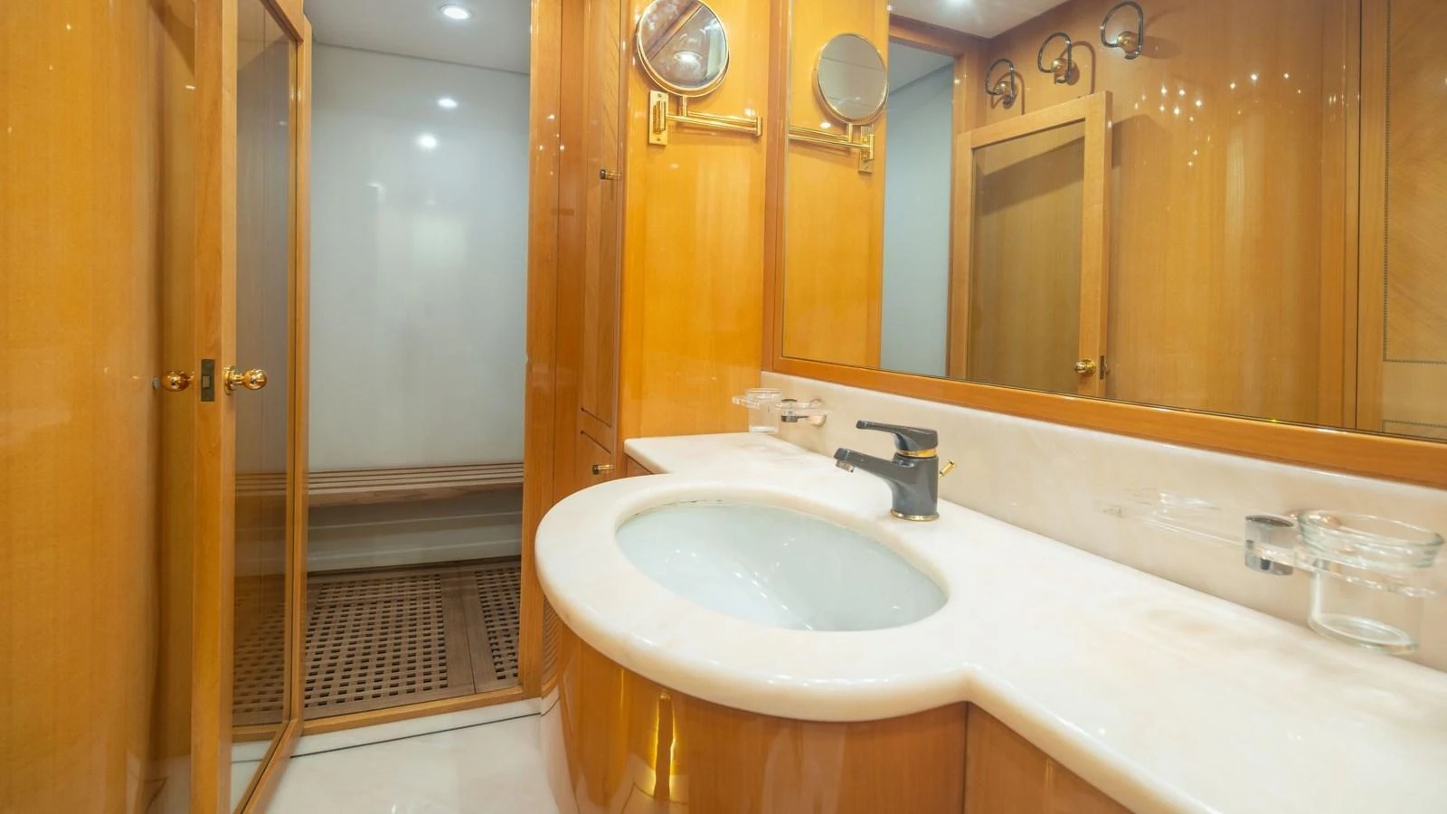 The yacht's bathroom features elegant wood paneling and a sleek countertop with a modern sink. aboard BLUE RIBBON Yacht for Sale