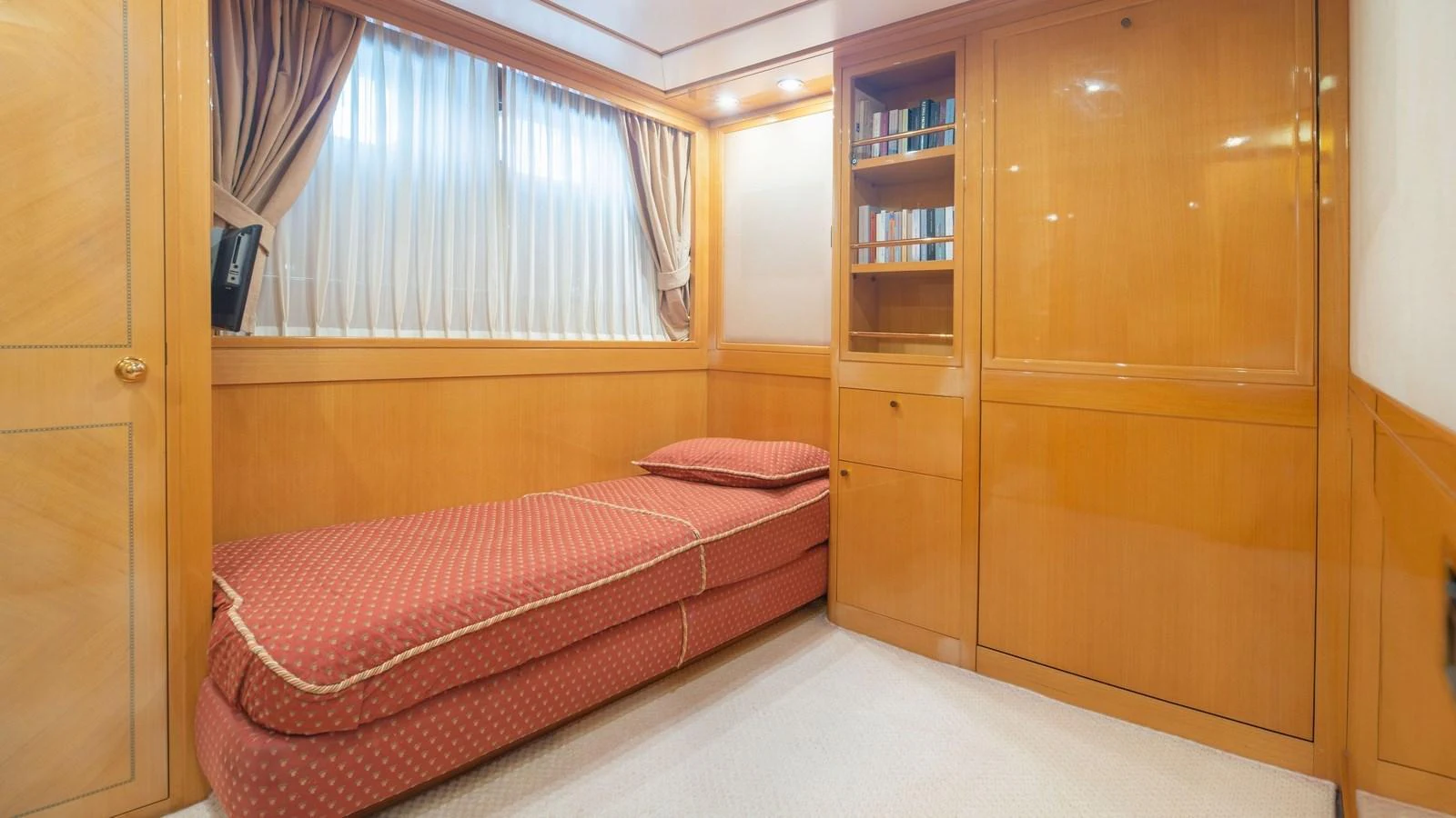 The guest stateroom features a single bed with elegant wood paneling and ample storage space. aboard BLUE RIBBON Yacht for Sale