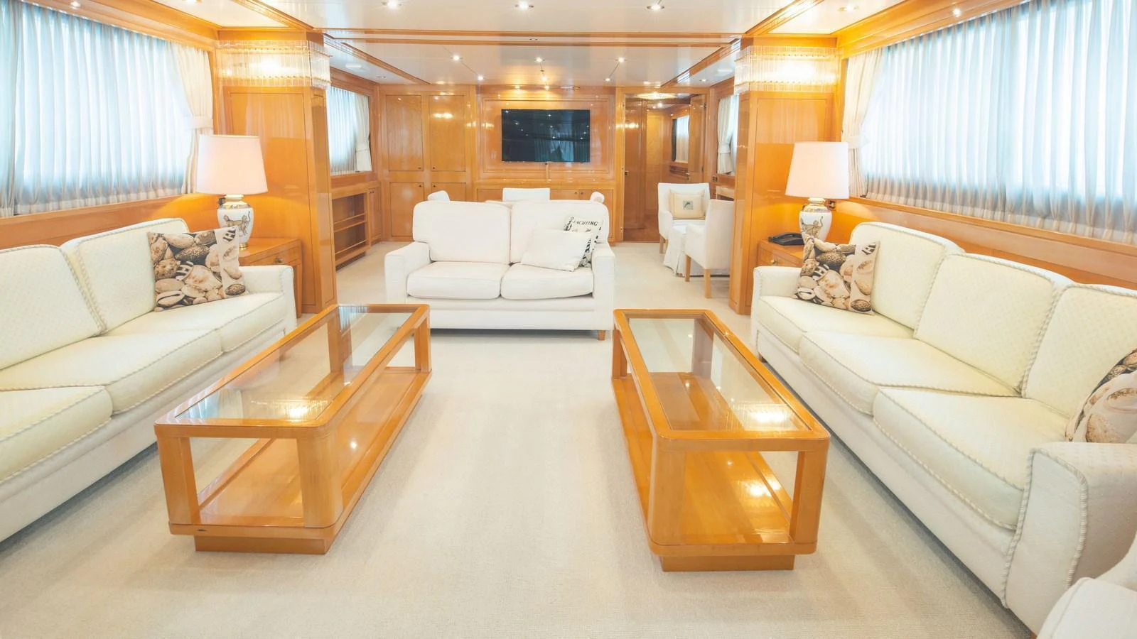 The salon features plush seating, elegant wooden accents, and ample natural light. aboard BLUE RIBBON Yacht for Sale