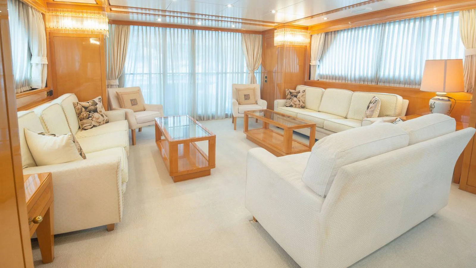 The salon features elegant seating with plush sofas and ample natural light. aboard BLUE RIBBON Yacht for Sale