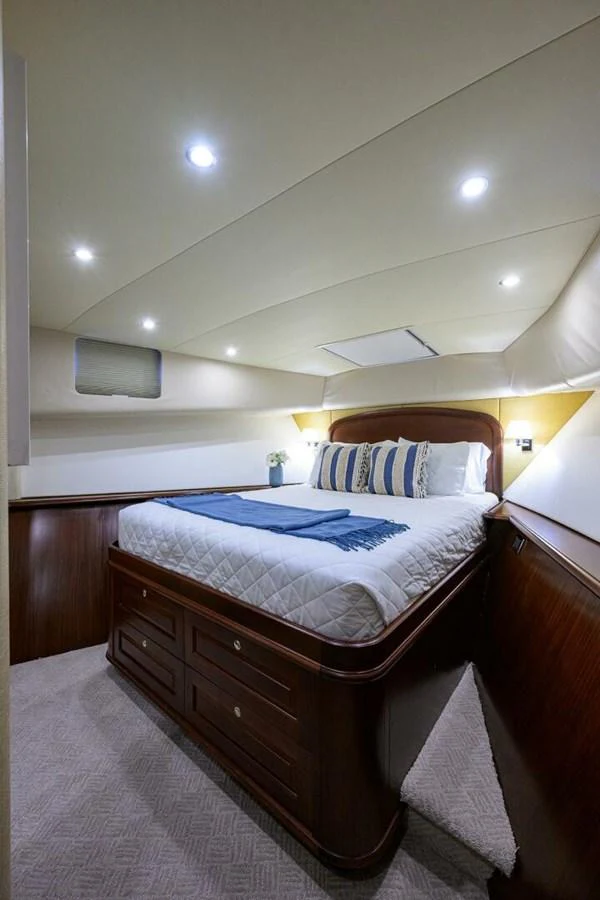 a bed with a blue and white striped pillow aboard JULE Yacht for Sale