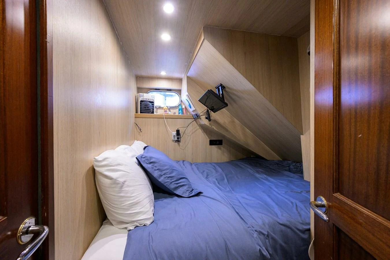a bed with a blue sheet aboard JULE Yacht for Sale