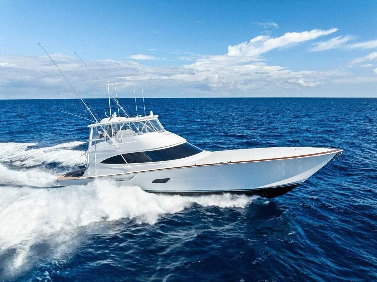 A sleek yacht cruises swiftly through the open ocean under a clear blue sky. aboard TEAM HARVEY I Yacht for Sale