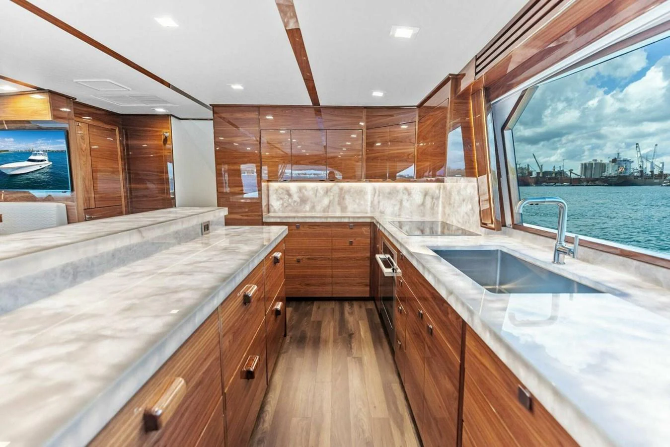 The galley features sleek wooden cabinetry, modern appliances, and expansive windows offering stunning ocean views. aboard TEAM HARVEY I Yacht for Sale