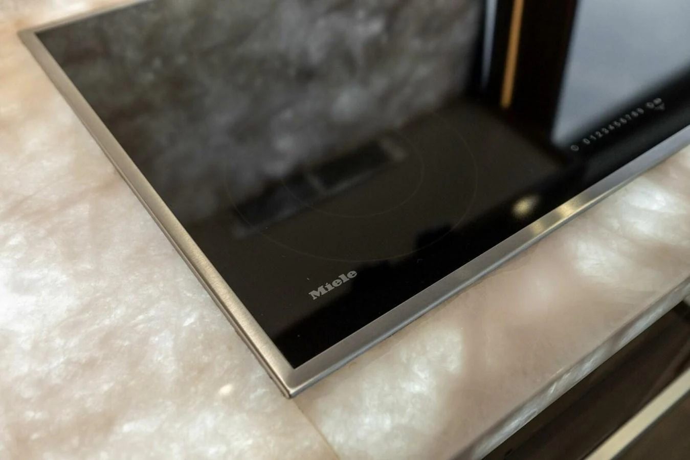 A sleek, modern cooktop is set into a luxurious marble countertop in the yacht's galley. aboard TEAM HARVEY I Yacht for Sale