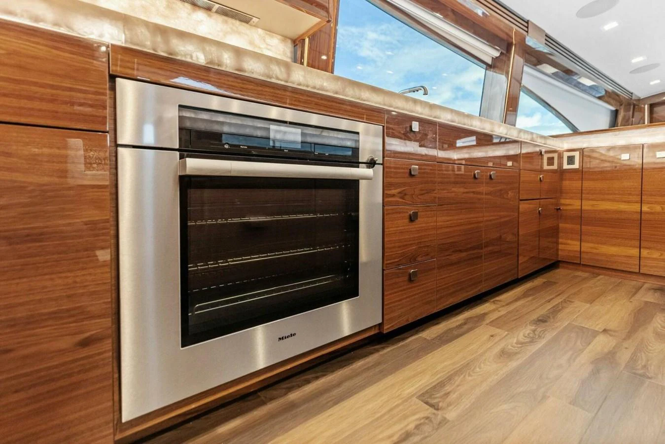 The yacht's galley features sleek wooden cabinetry and modern appliances, creating a warm and functional space. aboard TEAM HARVEY I Yacht for Sale