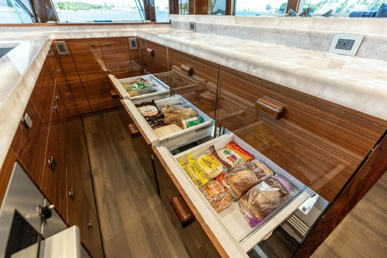 The galley features sleek wooden cabinetry with well-organized drawers stocked with provisions. aboard TEAM HARVEY I Yacht for Sale