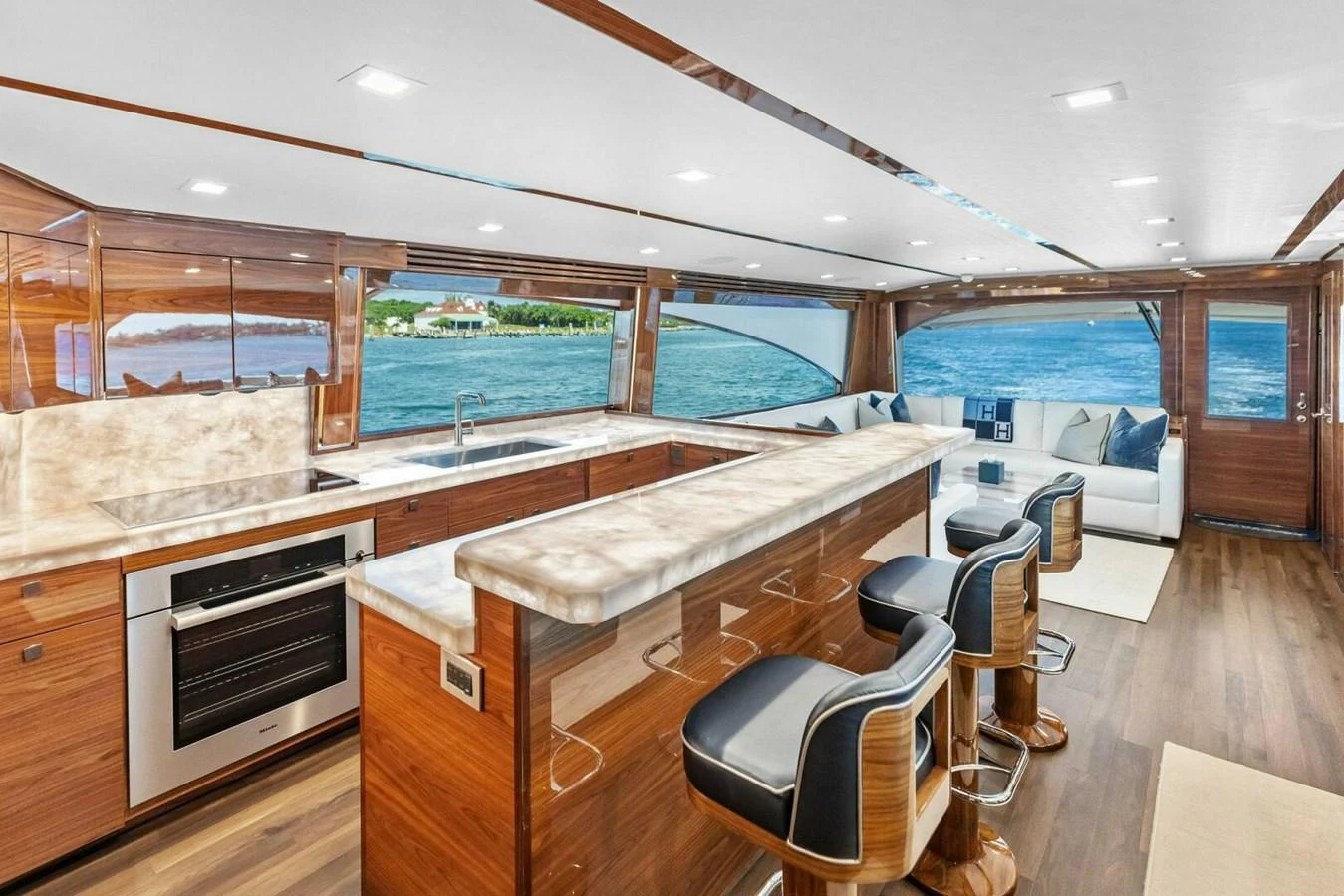 The yacht's galley features a luxurious marble countertop and comfortable seating with a stunning ocean view. aboard TEAM HARVEY I Yacht for Sale