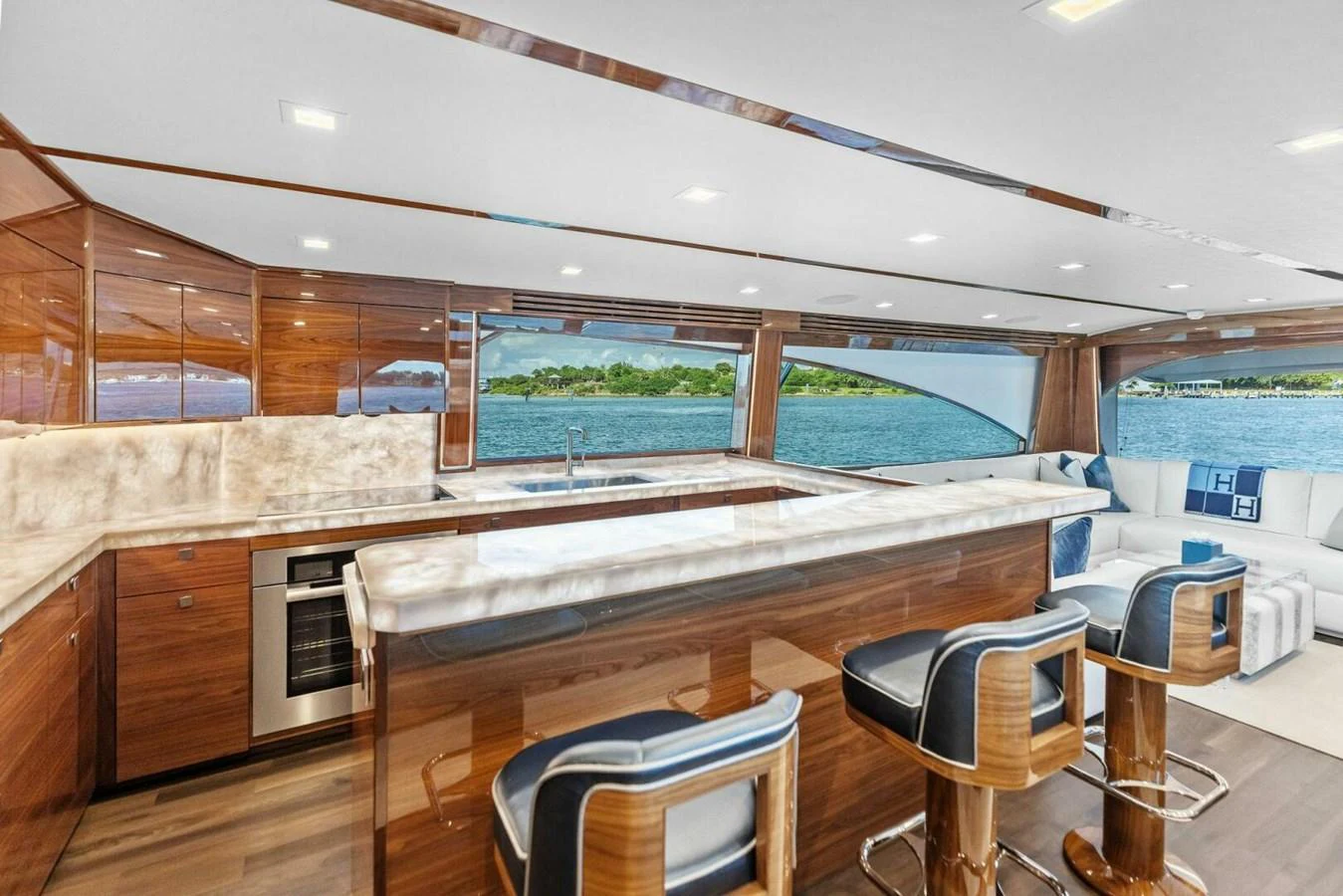 The yacht's galley features luxurious wood finishes, modern appliances, and a stunning view through large windows. aboard TEAM HARVEY I Yacht for Sale