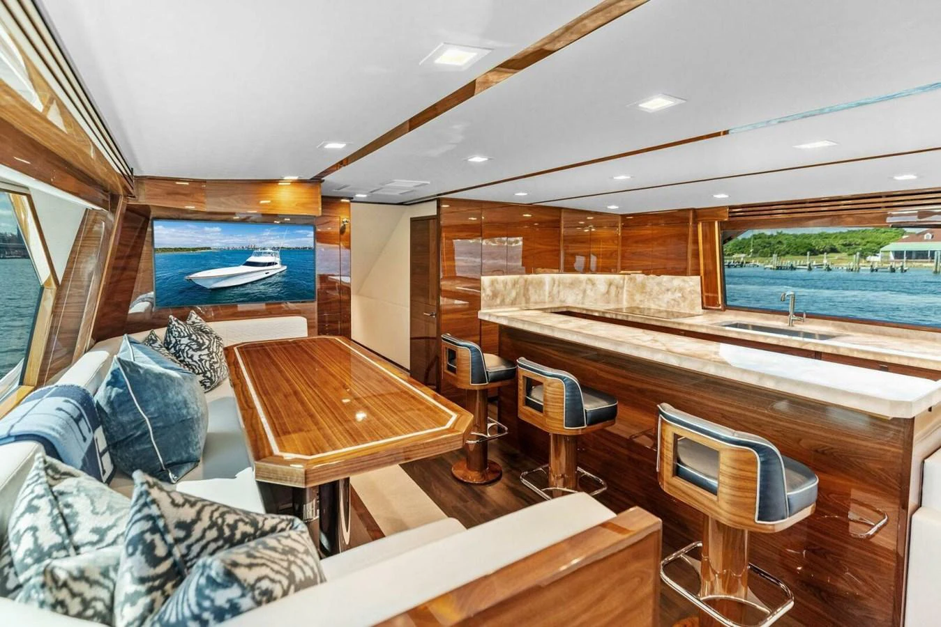 The yacht's salon features luxurious wooden finishes, a comfortable seating area, and a stylish bar with stools. aboard TEAM HARVEY I Yacht for Sale