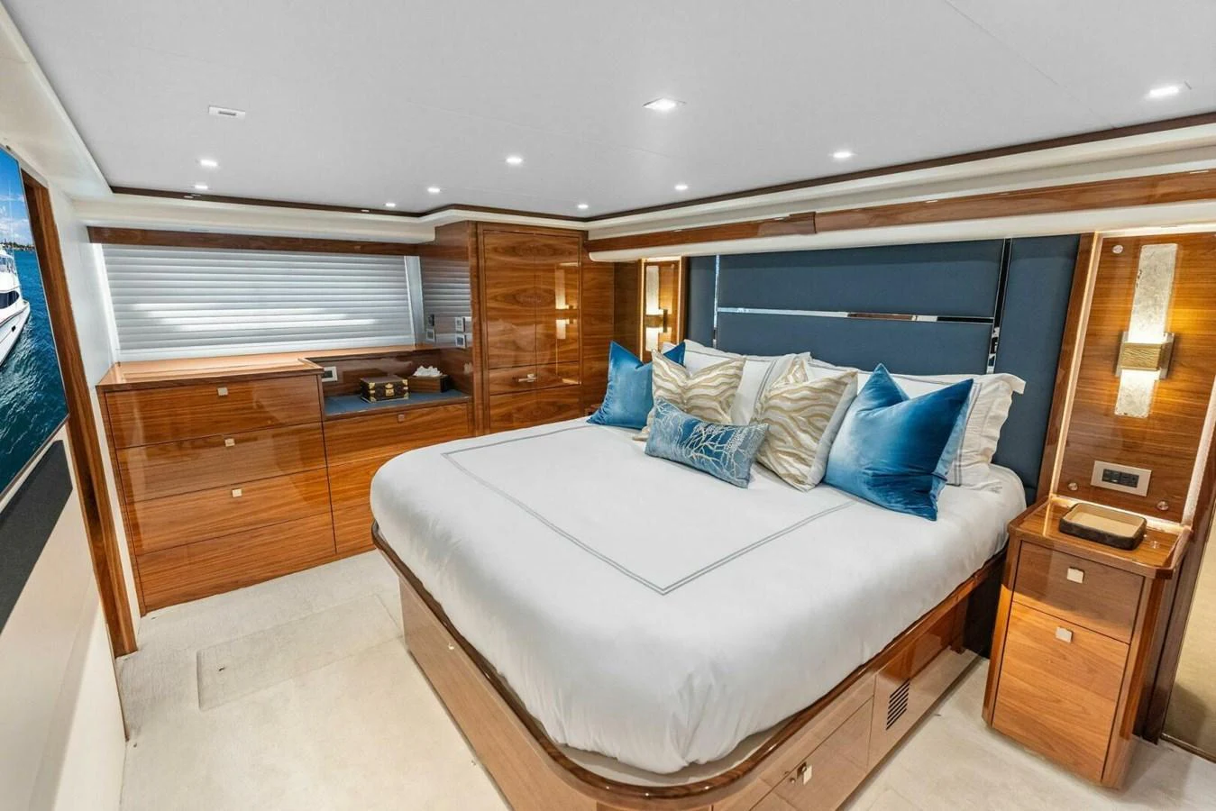 The master stateroom features a luxurious bed with plush pillows and elegant wooden cabinetry. aboard TEAM HARVEY I Yacht for Sale
