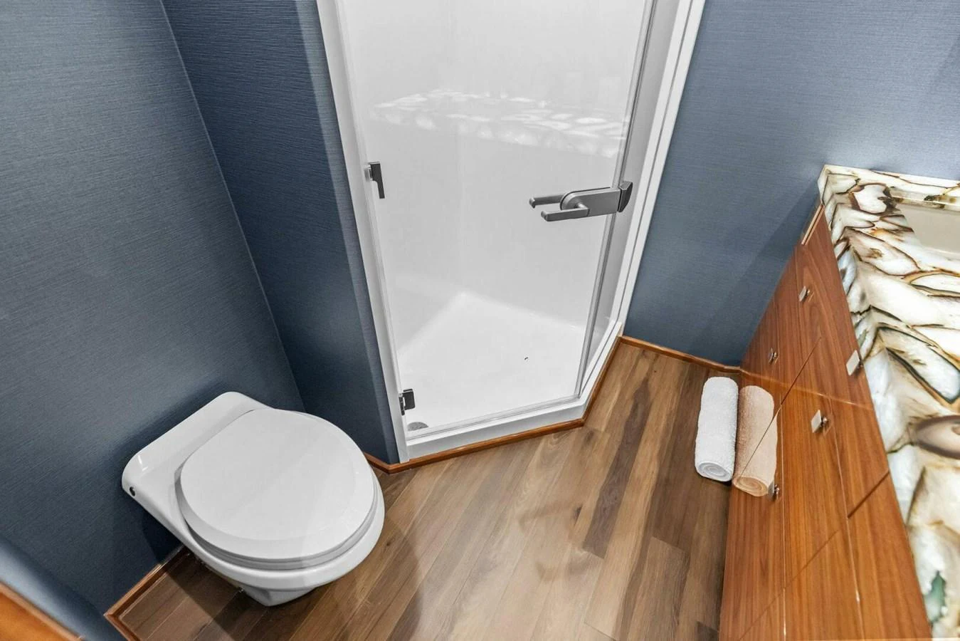 A modern yacht bathroom featuring a sleek shower and elegant wooden cabinetry. aboard TEAM HARVEY I Yacht for Sale