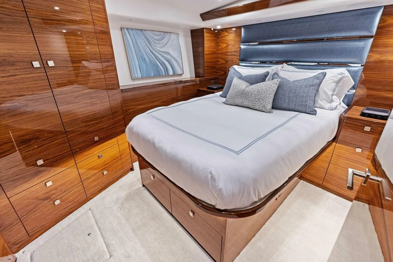 A luxurious stateroom featuring a plush bed with elegant bedding and rich wooden cabinetry. aboard TEAM HARVEY I Yacht for Sale