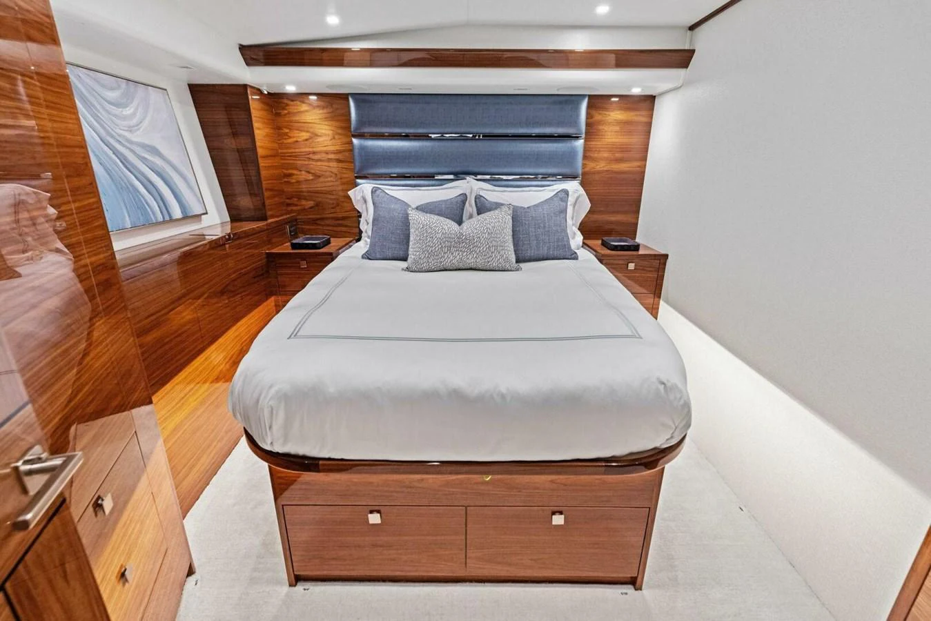 The stateroom features a luxurious bed with elegant wood paneling and modern lighting. aboard TEAM HARVEY I Yacht for Sale
