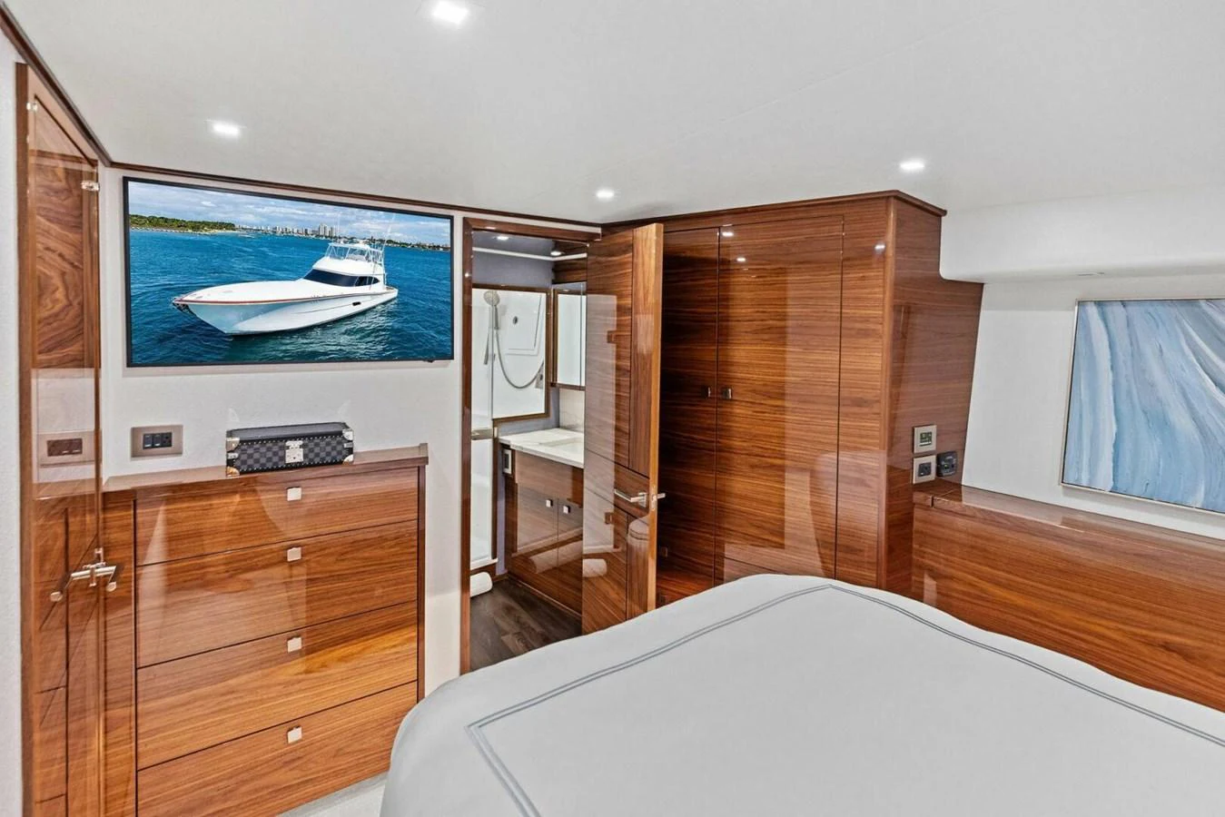 The stateroom features elegant wood finishes, a comfortable bed, and a flat-screen TV. aboard TEAM HARVEY I Yacht for Sale