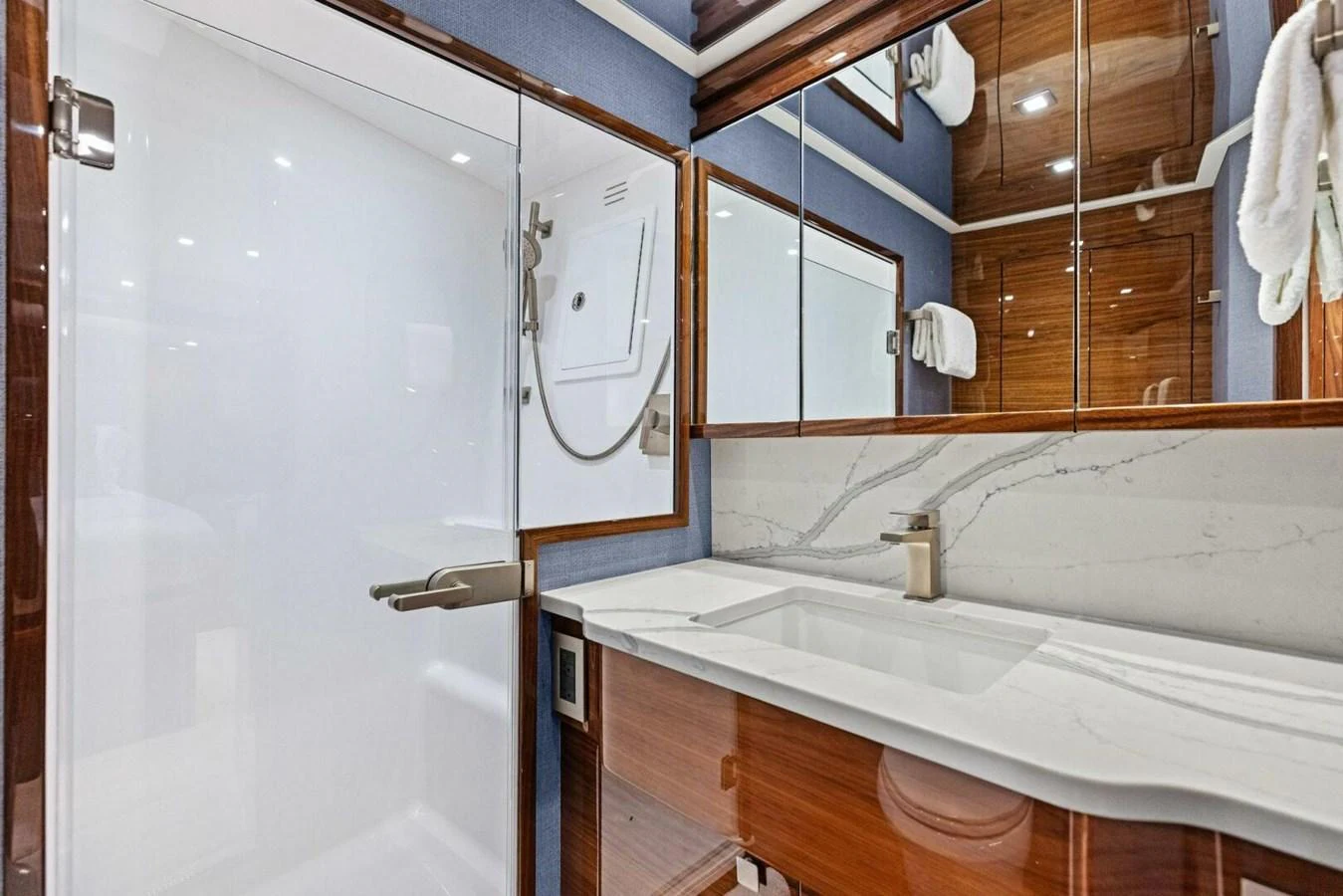 The yacht's bathroom features a sleek, modern design with a spacious shower and elegant fixtures. aboard TEAM HARVEY I Yacht for Sale