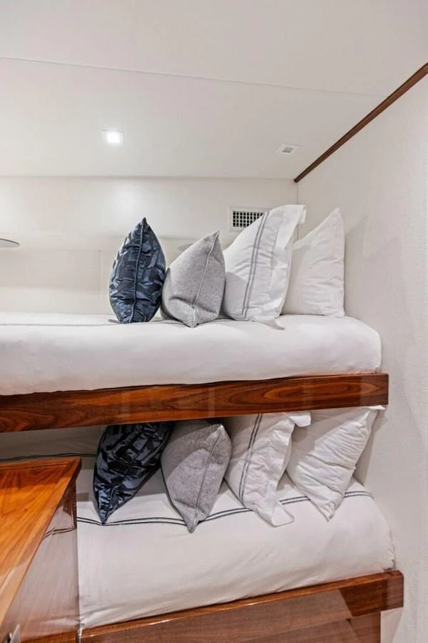The cozy bunk cabin features neatly arranged beds with plush pillows, creating a comfortable and inviting space. aboard TEAM HARVEY I Yacht for Sale