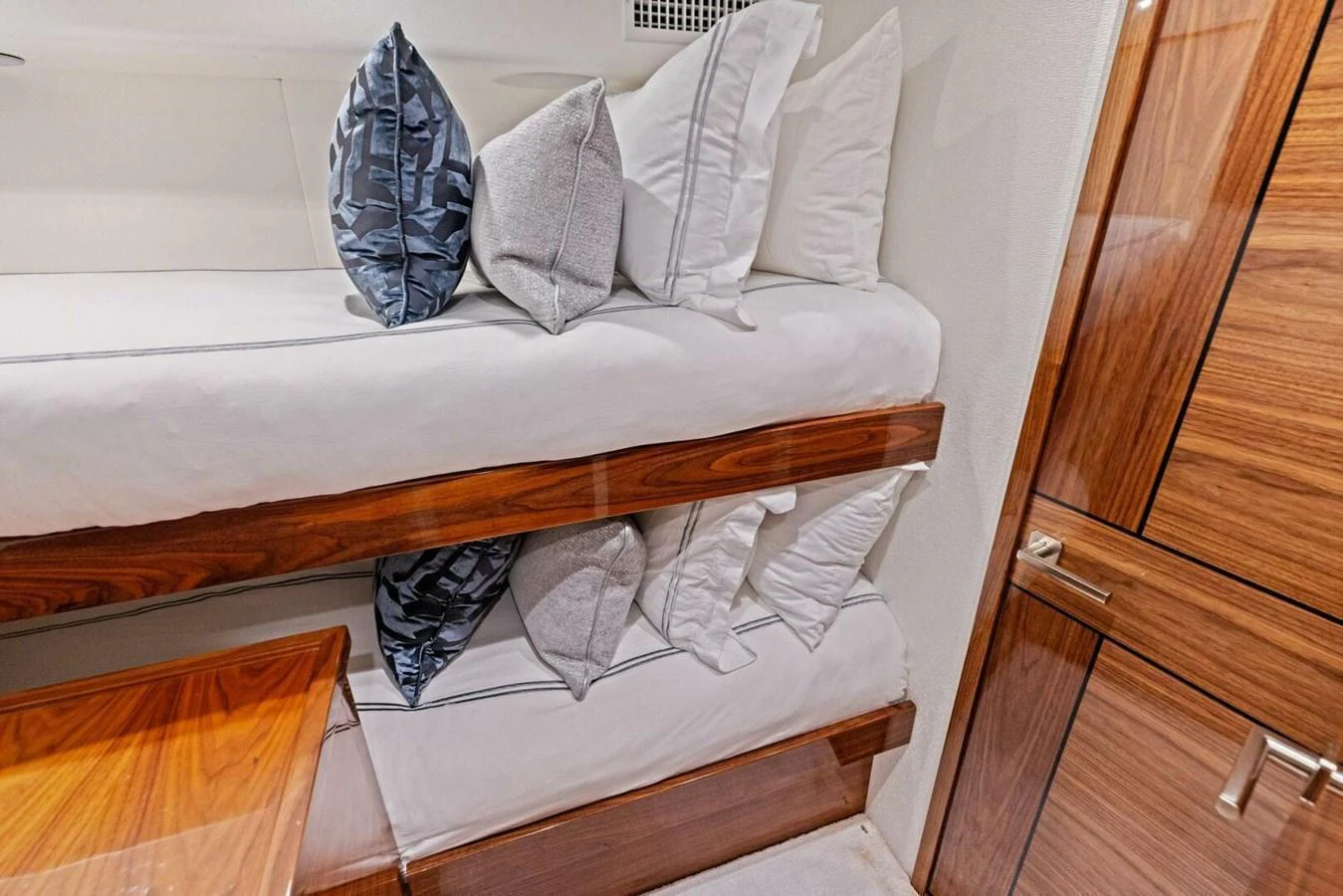 This cozy bunk cabin features comfortable bedding and elegant wooden cabinetry. aboard TEAM HARVEY I Yacht for Sale