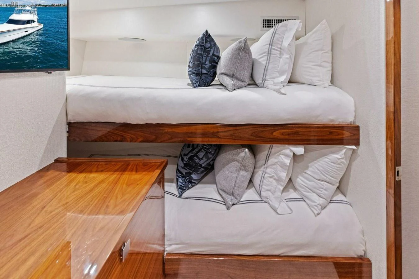 The guest cabin features cozy bunk beds with plush pillows and a polished wooden finish. aboard TEAM HARVEY I Yacht for Sale