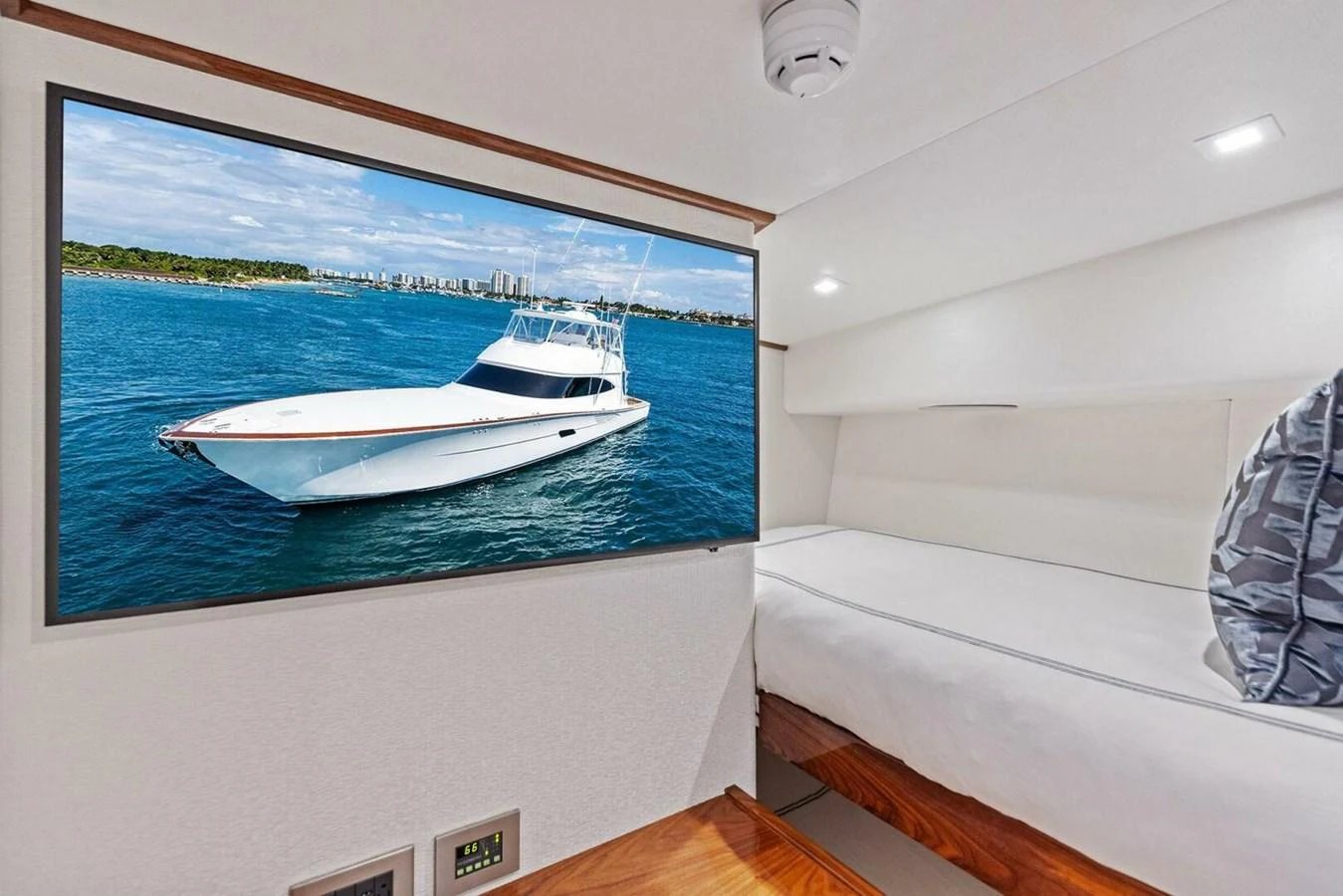 A cozy yacht cabin featuring a comfortable bed and a large window displaying a scenic view of the sea. aboard TEAM HARVEY I Yacht for Sale