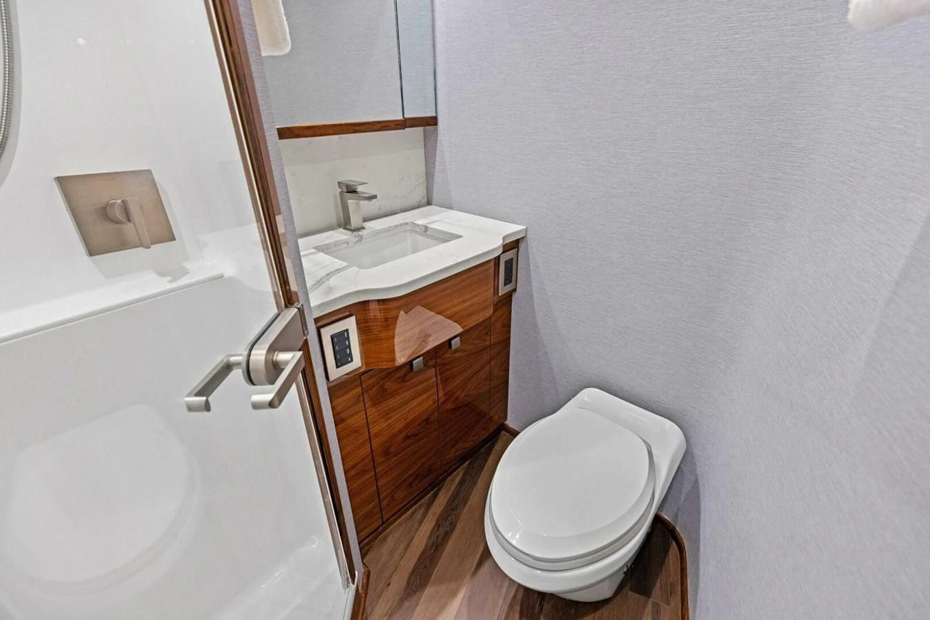 A modern yacht bathroom featuring a sleek vanity and a compact toilet. aboard TEAM HARVEY I Yacht for Sale