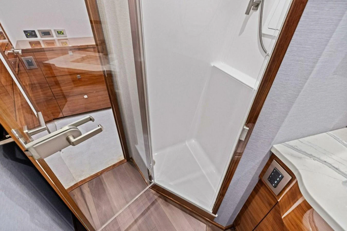 A sleek and modern yacht bathroom with a glass-enclosed shower and wooden accents. aboard TEAM HARVEY I Yacht for Sale