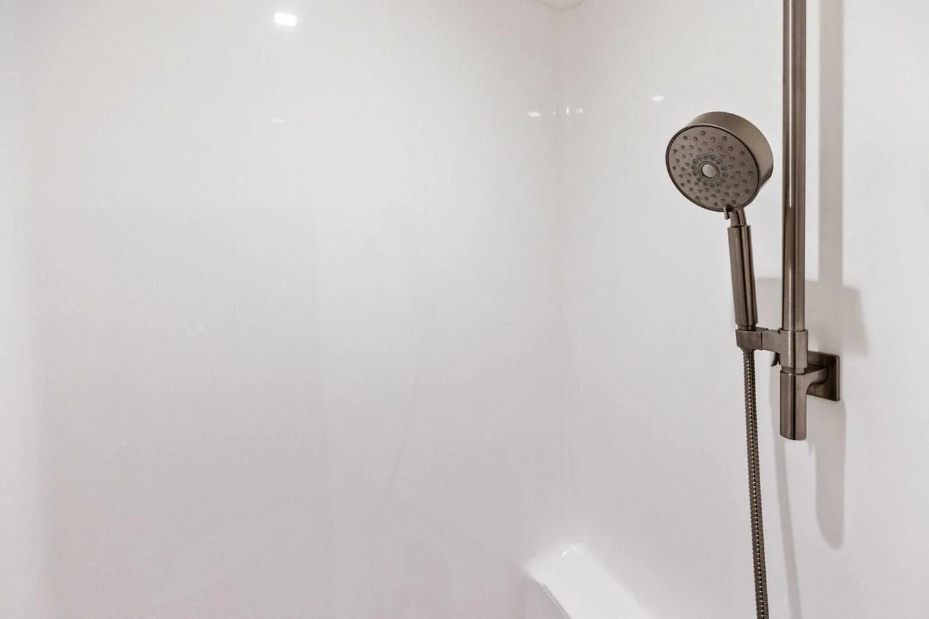 A sleek and modern shower area with a handheld showerhead. aboard TEAM HARVEY I Yacht for Sale