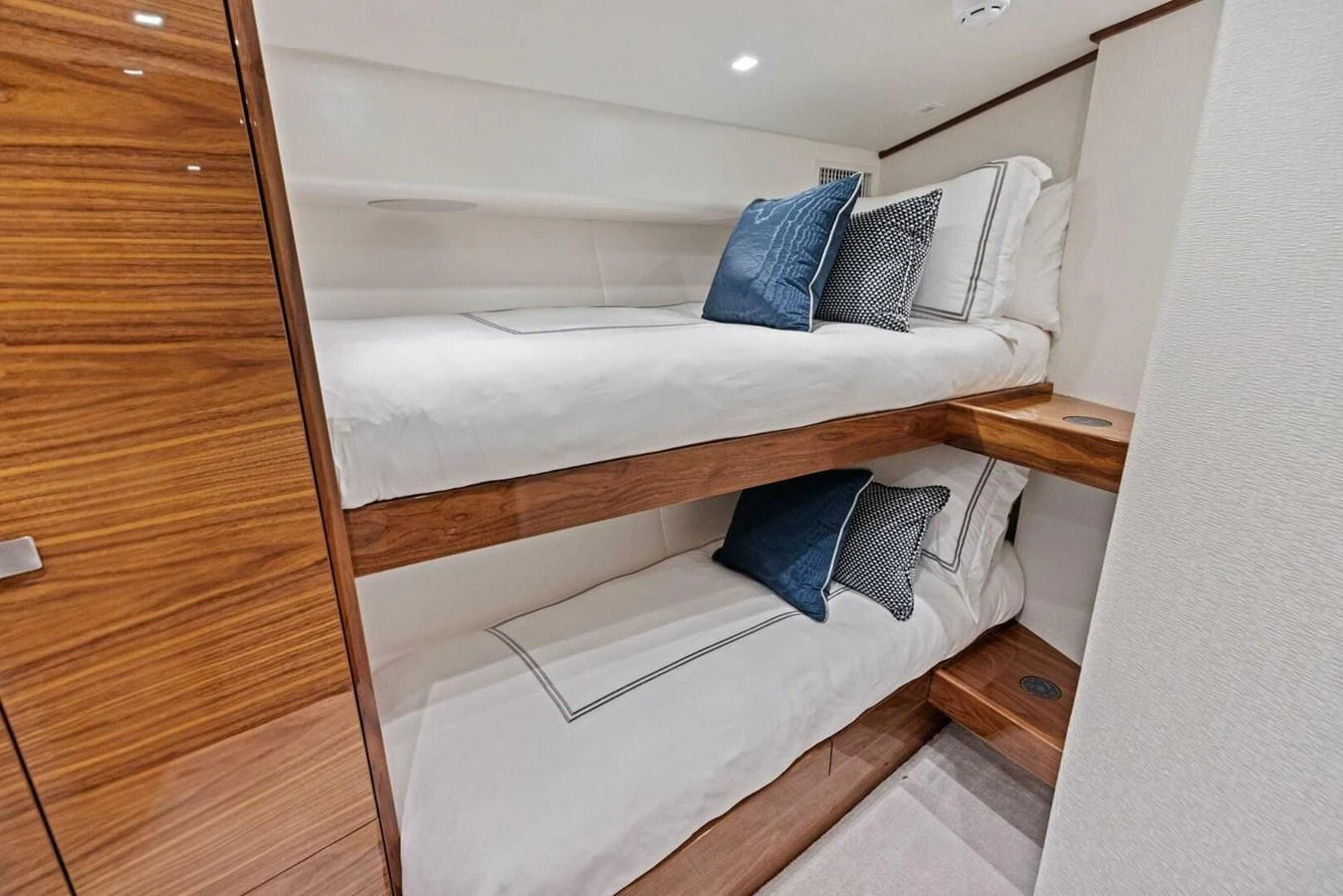 The guest cabin features cozy bunk beds with elegant bedding and wood accents. aboard TEAM HARVEY I Yacht for Sale