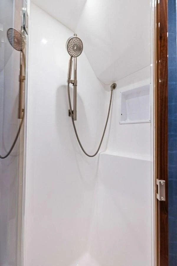 A sleek and modern yacht shower with a handheld showerhead and minimalist design. aboard TEAM HARVEY I Yacht for Sale
