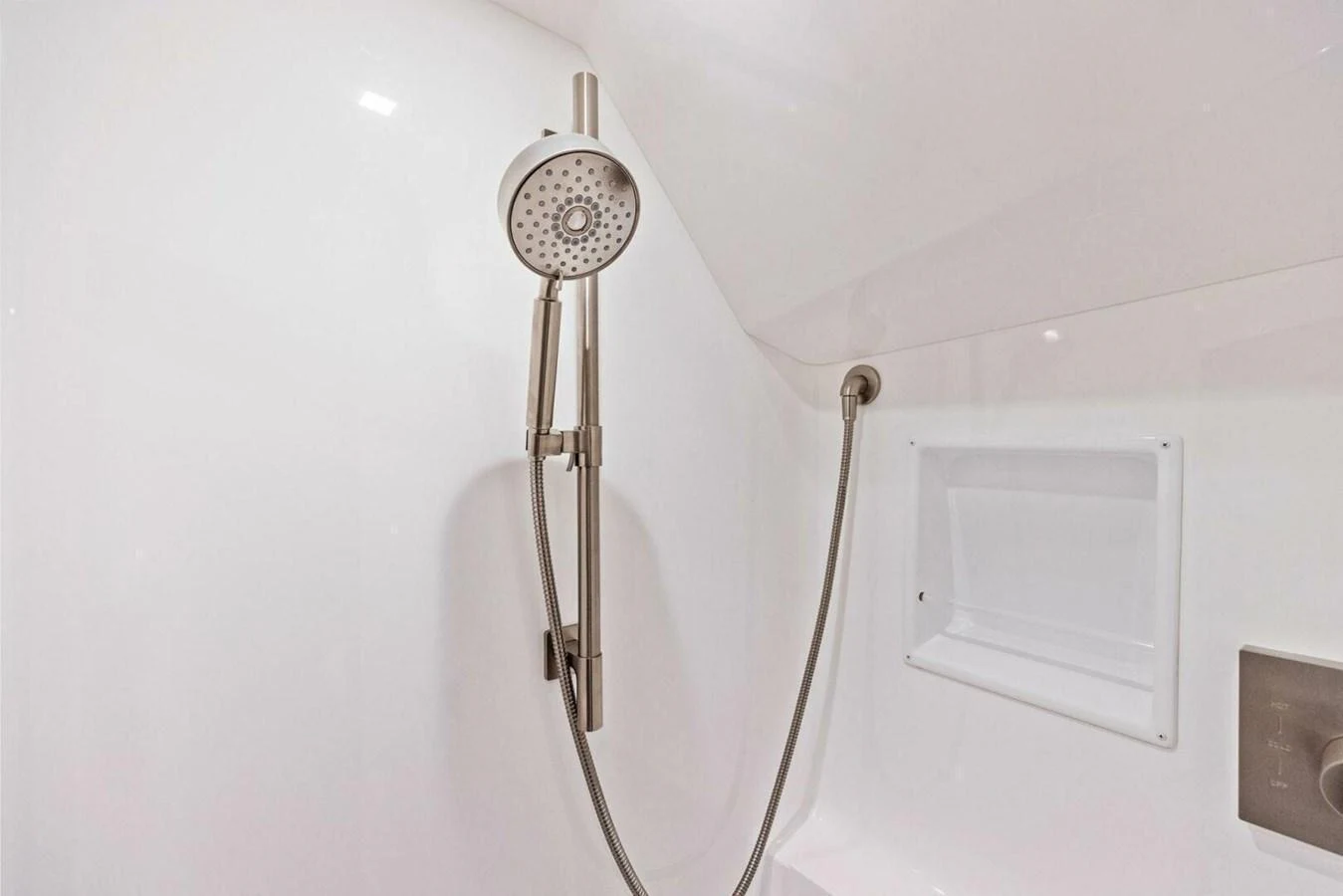 A sleek, modern shower with a handheld showerhead and built-in shelf. aboard TEAM HARVEY I Yacht for Sale