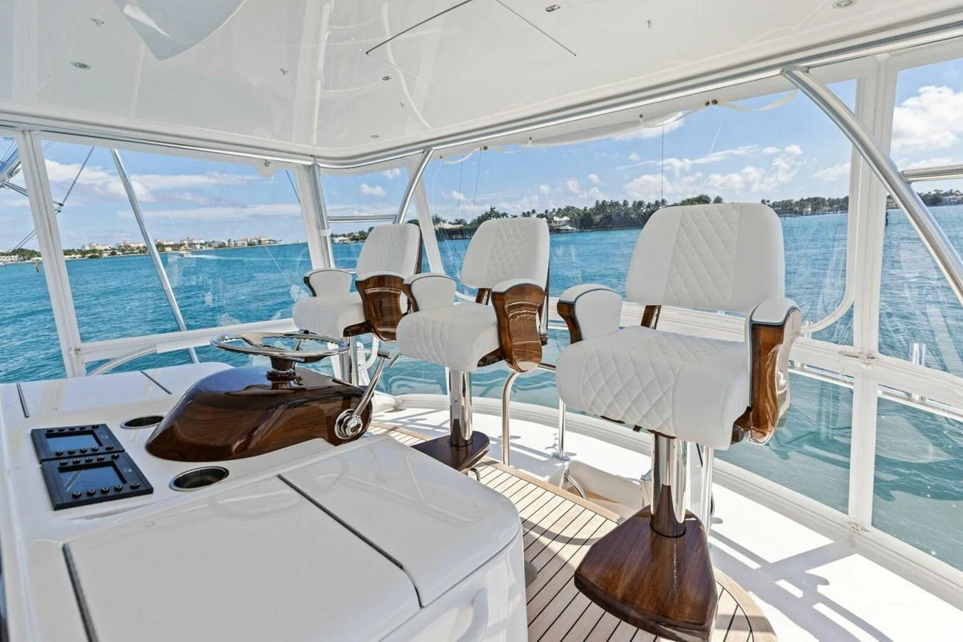 The helm area features luxurious white seating with a panoramic view of the surrounding waters. aboard TEAM HARVEY I Yacht for Sale