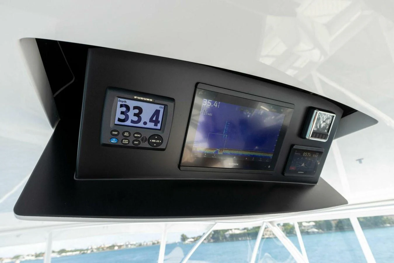 A close-up of the helm's electronic display panel showcasing navigation and speed instruments. aboard TEAM HARVEY I Yacht for Sale
