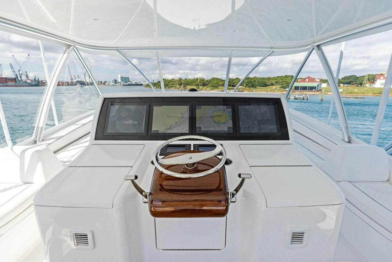The helm station features a sleek design with advanced navigation screens and a polished wooden steering wheel. aboard TEAM HARVEY I Yacht for Sale