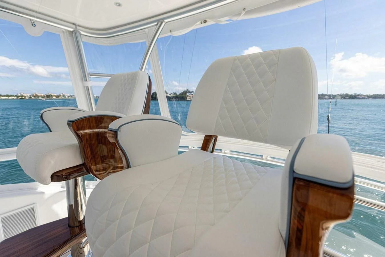 Elegant helm chairs with quilted upholstery and wooden accents offer a luxurious seating experience. aboard TEAM HARVEY I Yacht for Sale