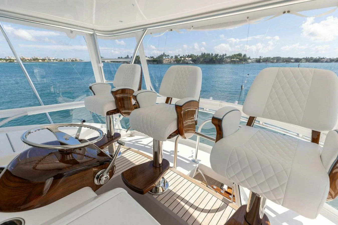 The helm area features luxurious white quilted chairs with a stunning view of the water. aboard TEAM HARVEY I Yacht for Sale