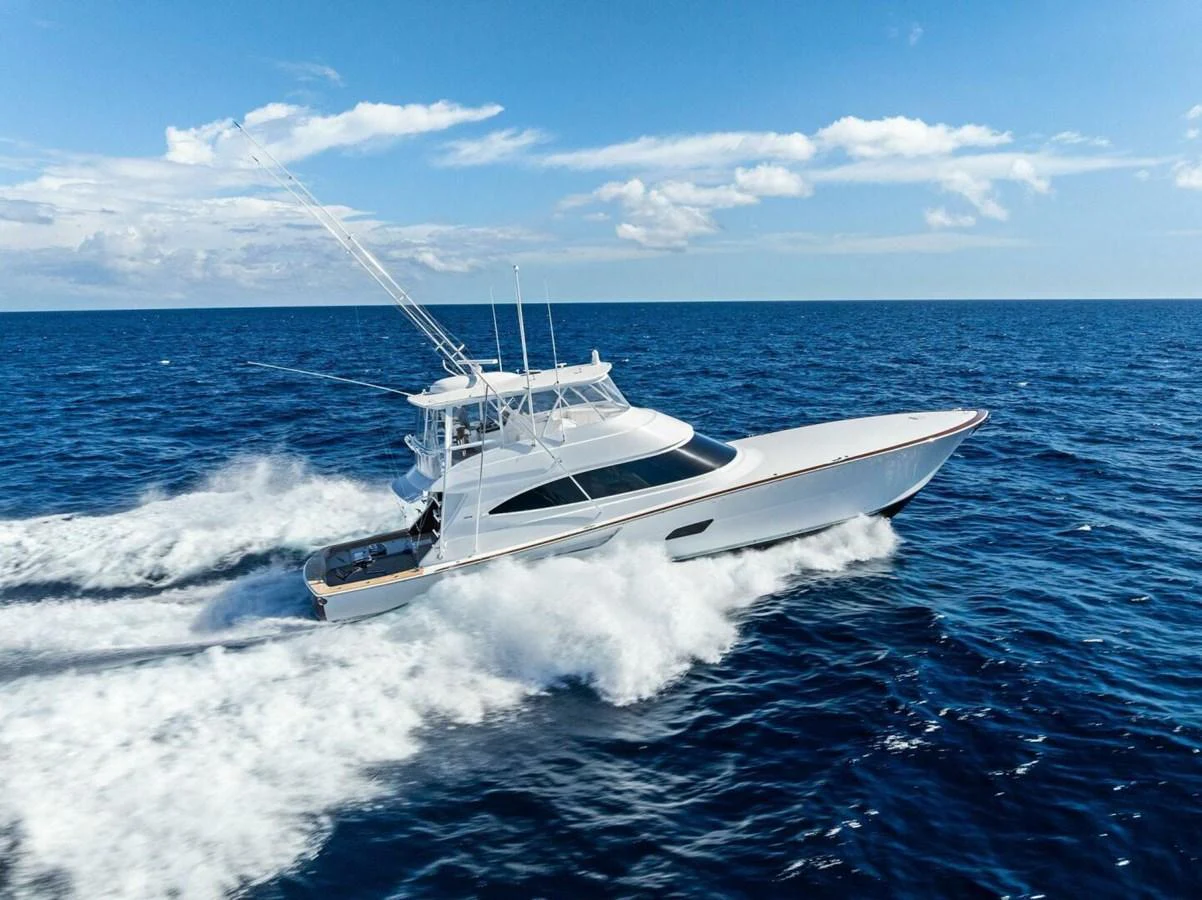 A sleek yacht cruises swiftly through the open sea under a clear blue sky. aboard TEAM HARVEY I Yacht for Sale