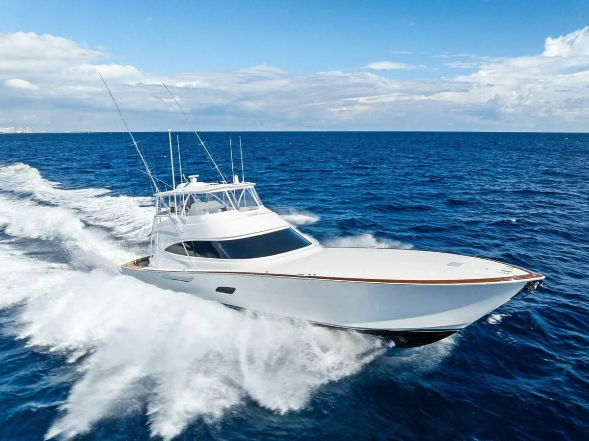 A sleek yacht cruises swiftly through the open ocean under a clear sky. aboard TEAM HARVEY I Yacht for Sale