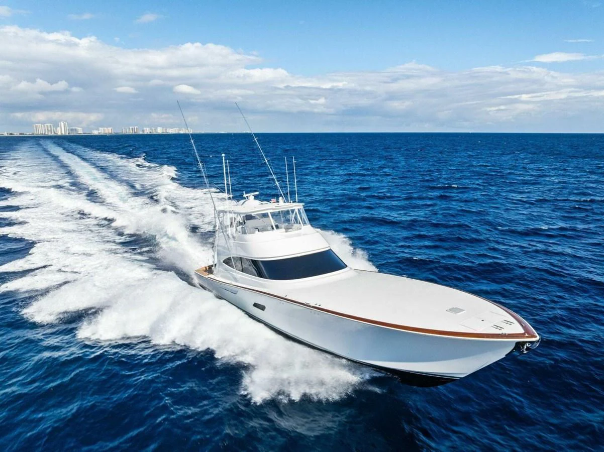 A sleek yacht cruises swiftly through the open ocean under a clear blue sky. aboard TEAM HARVEY I Yacht for Sale