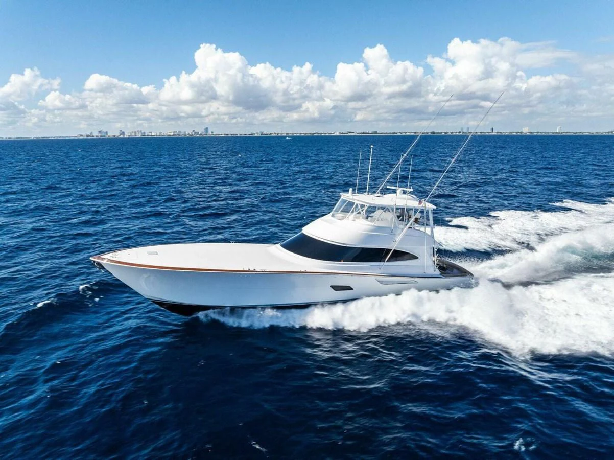 A sleek yacht cruises swiftly through the open ocean under a bright blue sky. aboard TEAM HARVEY I Yacht for Sale
