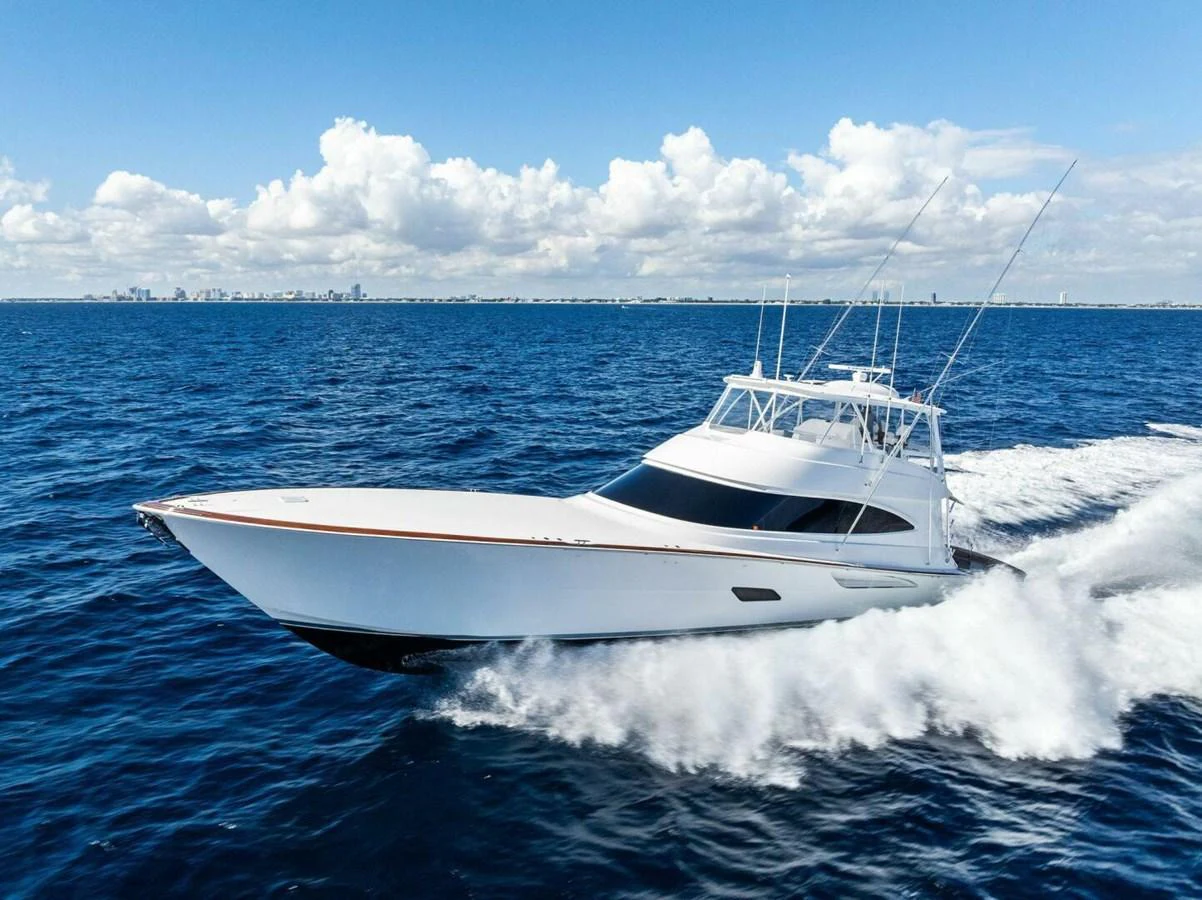 A sleek yacht cruises swiftly over the open ocean under a bright blue sky. aboard TEAM HARVEY I Yacht for Sale