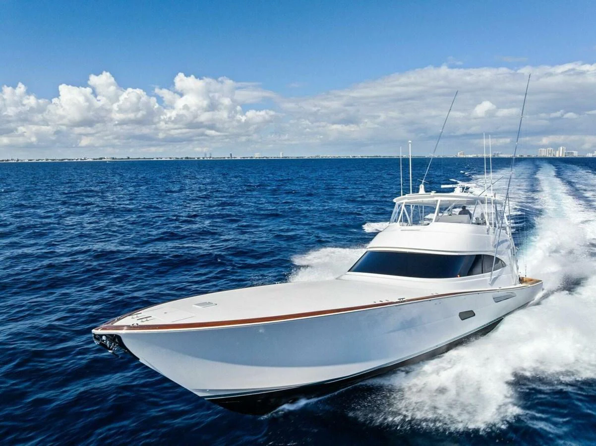 A sleek yacht cruises swiftly across the open ocean under a clear blue sky. aboard TEAM HARVEY I Yacht for Sale