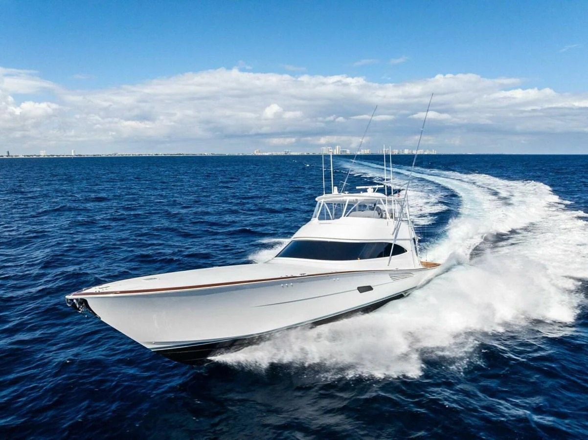 A sleek yacht cruises swiftly through the open ocean under a clear blue sky. aboard TEAM HARVEY I Yacht for Sale