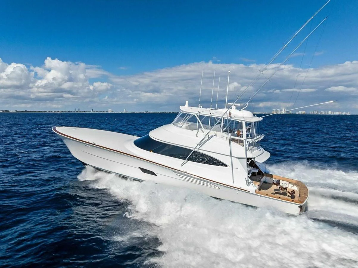 A sleek yacht cruises swiftly through the open sea under a clear blue sky. aboard TEAM HARVEY I Yacht for Sale
