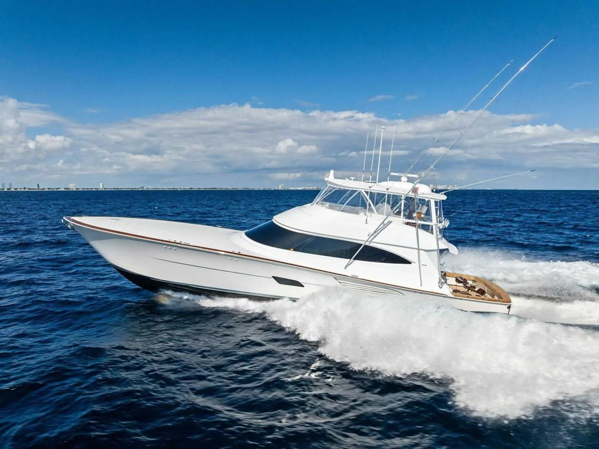 A sleek yacht cruises swiftly through the open ocean under a clear blue sky. aboard TEAM HARVEY I Yacht for Sale