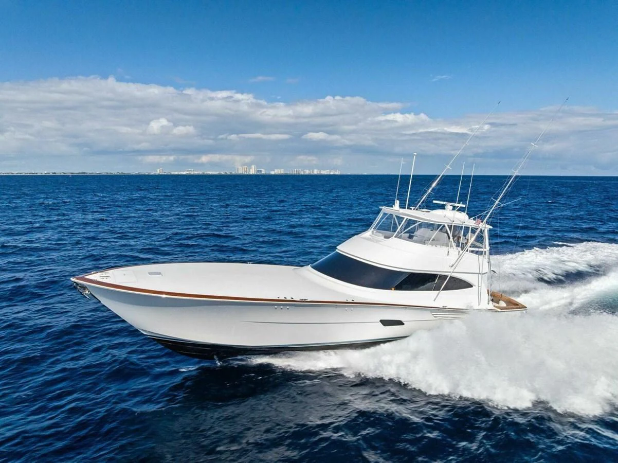 A sleek yacht cruises swiftly through the open sea under a clear blue sky. aboard TEAM HARVEY I Yacht for Sale